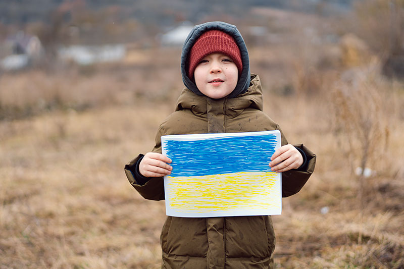 Child holding up Ukraine Flag